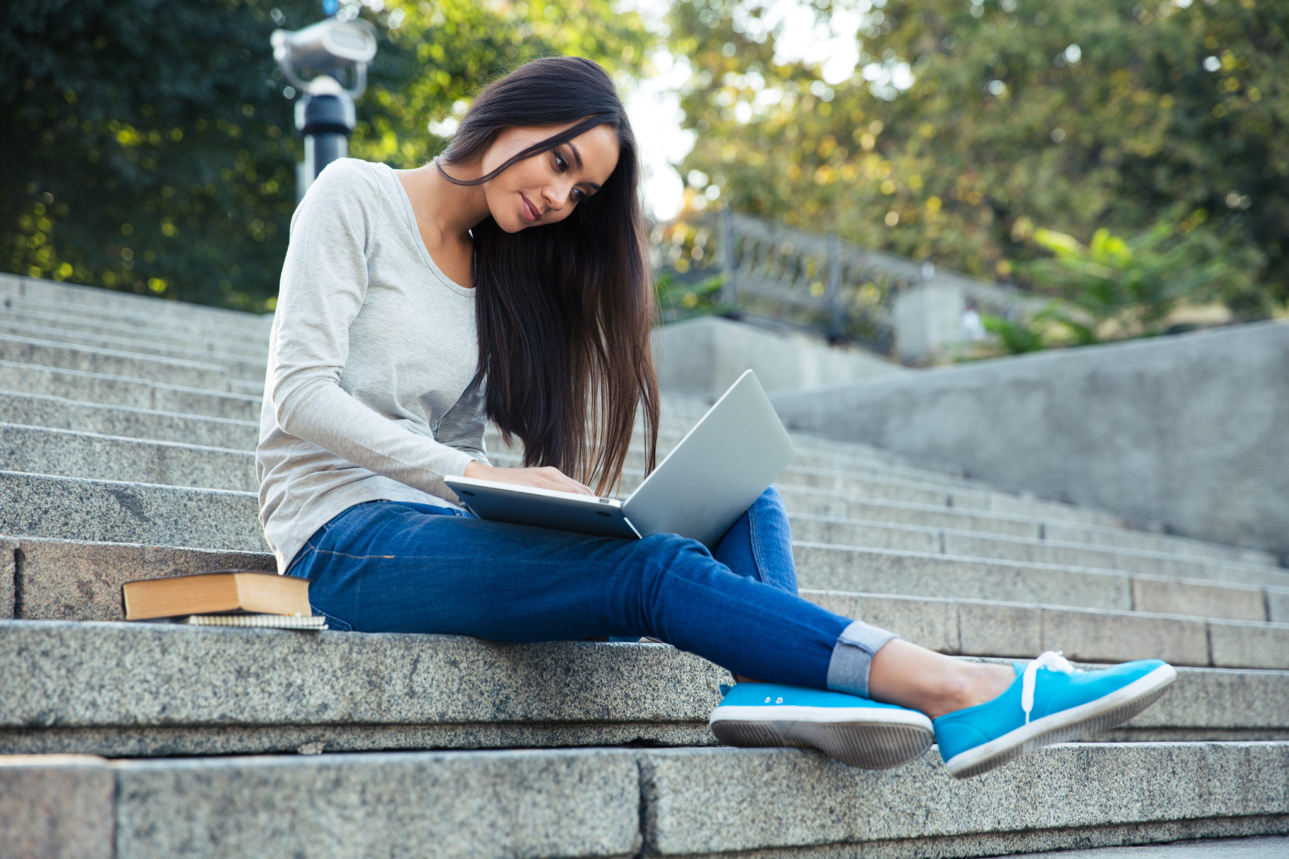 Female college student studying outside on city stairs