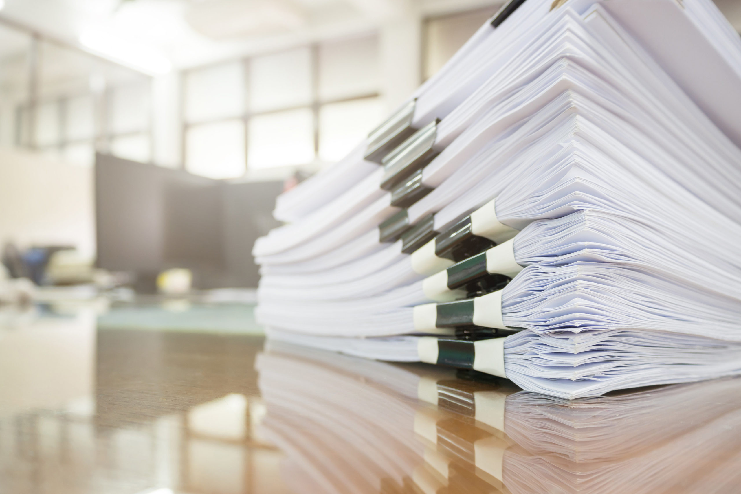 Pile of unfinished documents on office desk