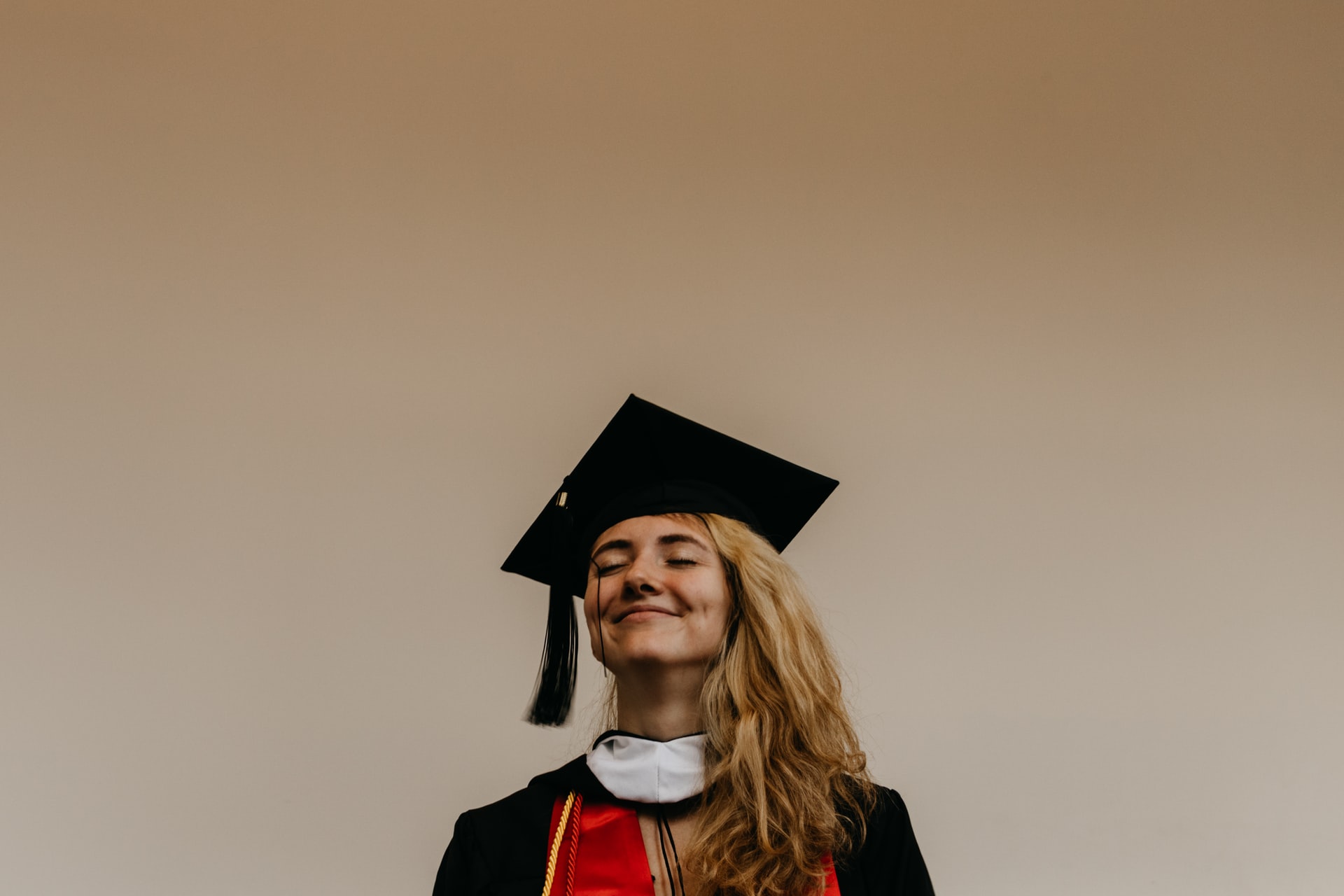 college graduate smiling and standing proudly